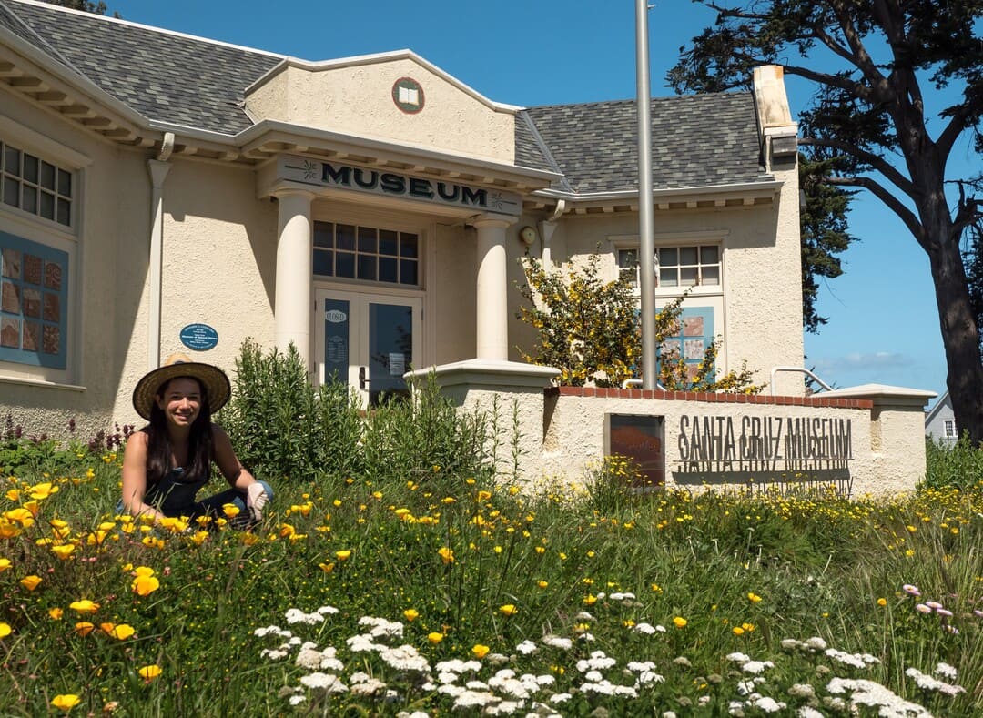 Front of the Santa Cruz Museum of Natural History building with a woman sitting in front